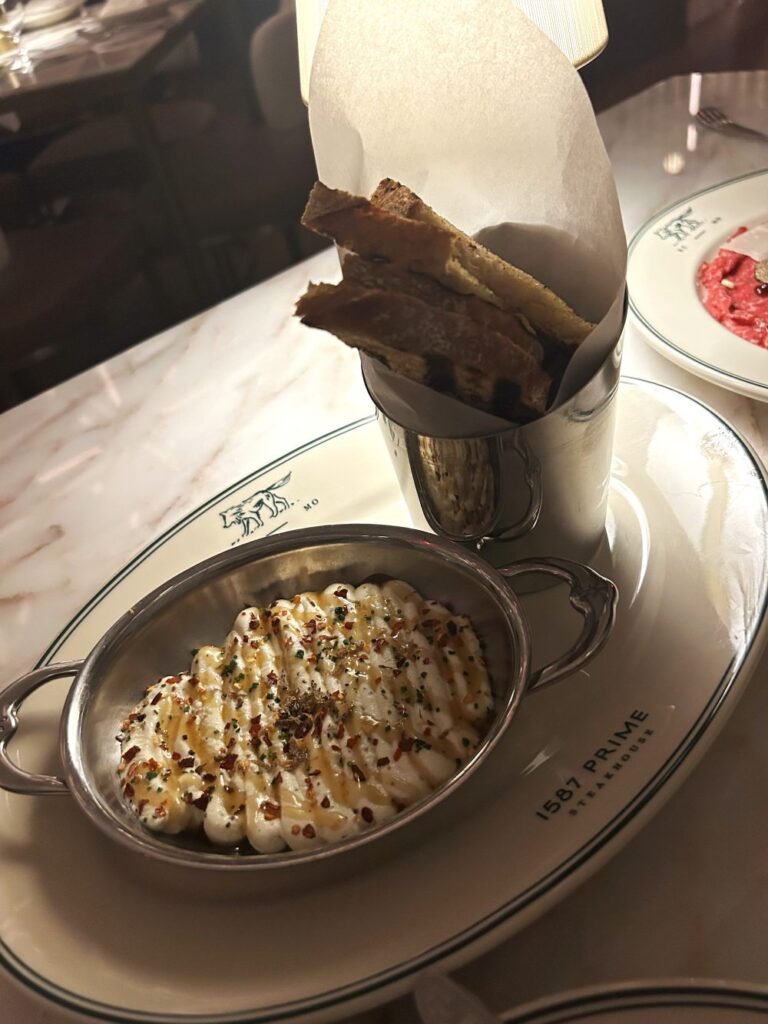 Whipped Ricotta with truffle honey, chili, black truffle, and toasted bread is a creamy dish served at 1587 Prime.