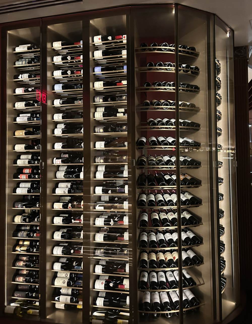 Impressive wine collection displayed on tall shelves reaching up to the ceiling in the sophisticated restaurant bar of 1587 Prime.