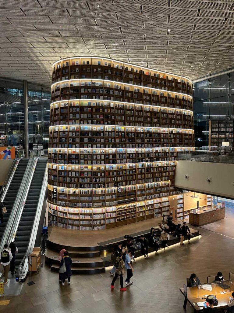 People relaxing and reading at Starfield Library surrounded by floor-to-ceiling bookshelves in the vibrant Gangnam district.