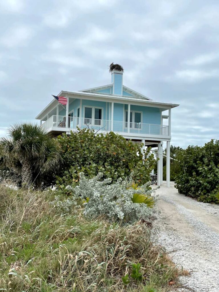 Elevated coastal cottage on North Captiva Island surrounded by palm trees