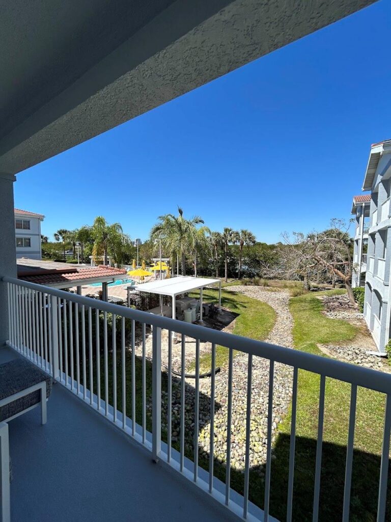 Pool area at DoubleTree Suites by Hilton Hotel Naples with palm trees and lounge chairs