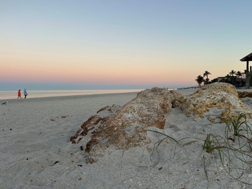 Sunset over the coastline in Bonita Springs in Southwest Florida with golden skies and calm waters