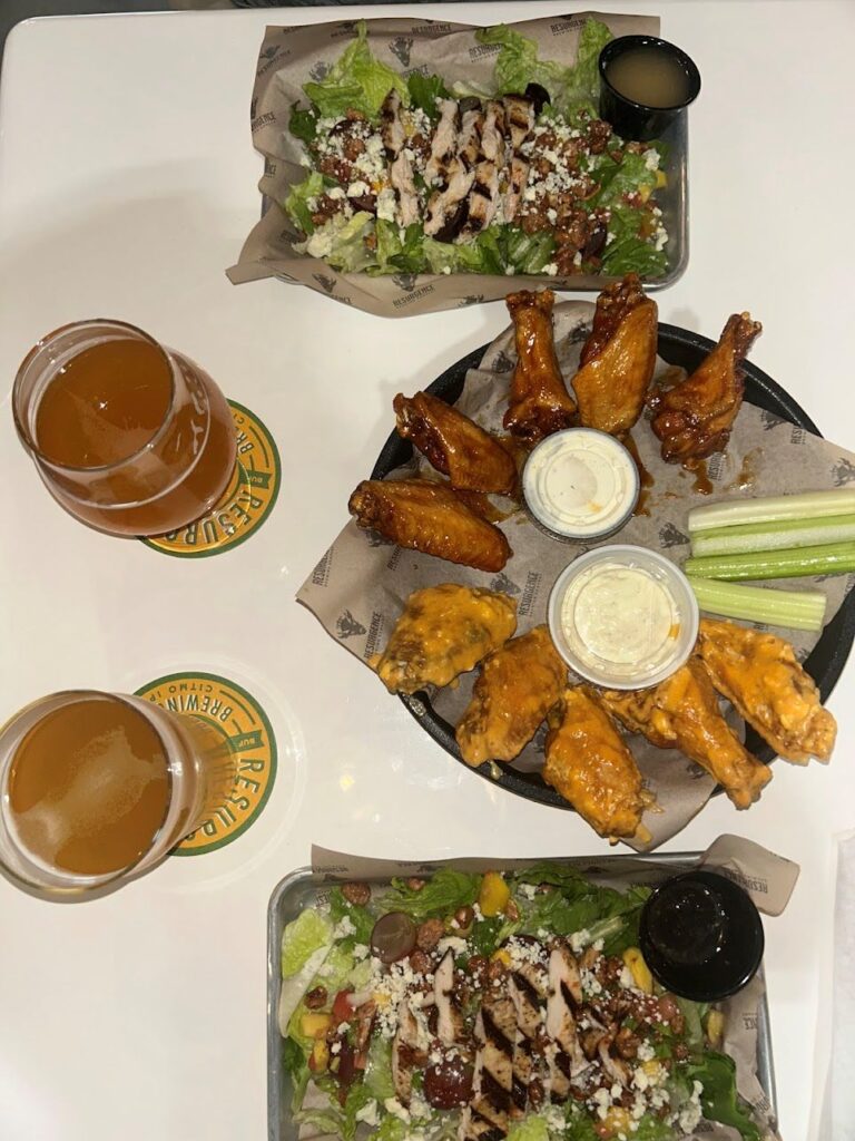 A platter of Buffalo wings, chicken salads and cocktails served at Resurgence Brewing Co. in Fort Myers, Florida