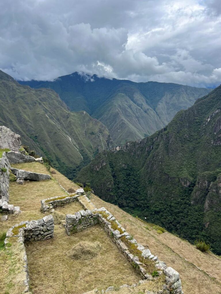 Wide-angle landscape of Machu Picchu with lush green terraces and dramatic peaks