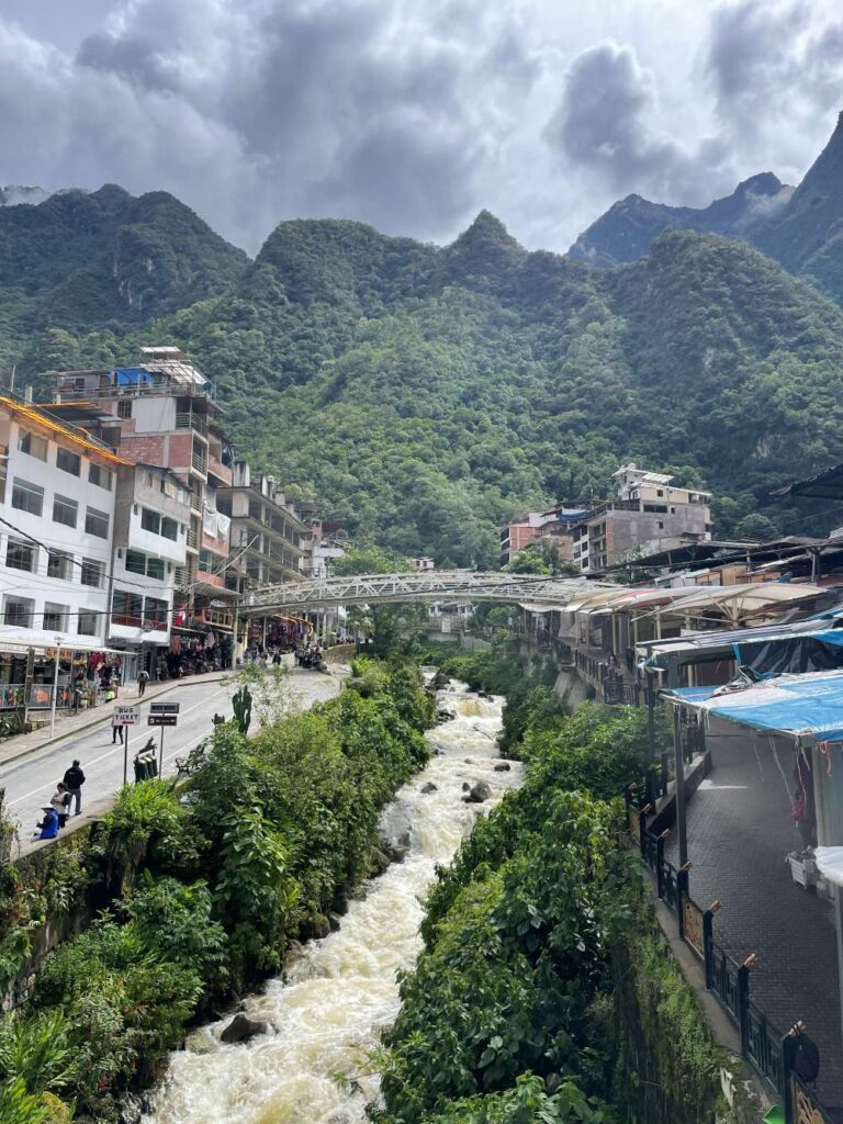 Scenic riverside view in Aguas Calientes surrounded by lush green mountains