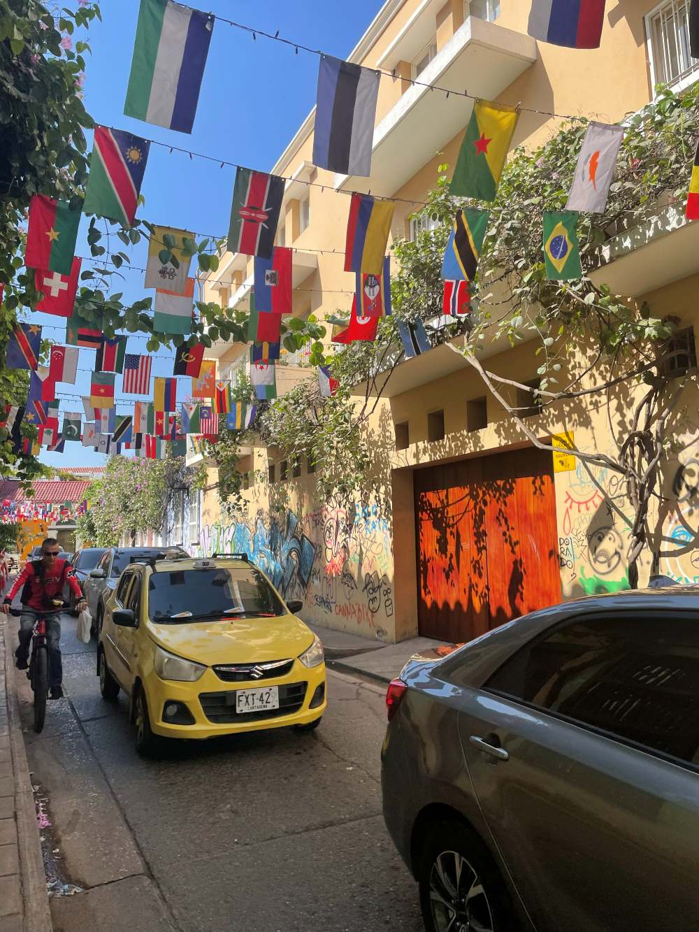 Lively street scene in Getsemaní with flags, graffiti, and colonial buildings in Cartagena