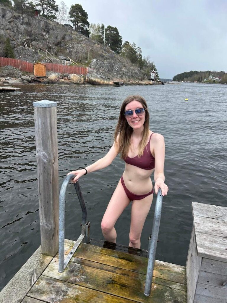A traveler ready to plunge into the chilling Nordic Sea after a floating sauna experience.
