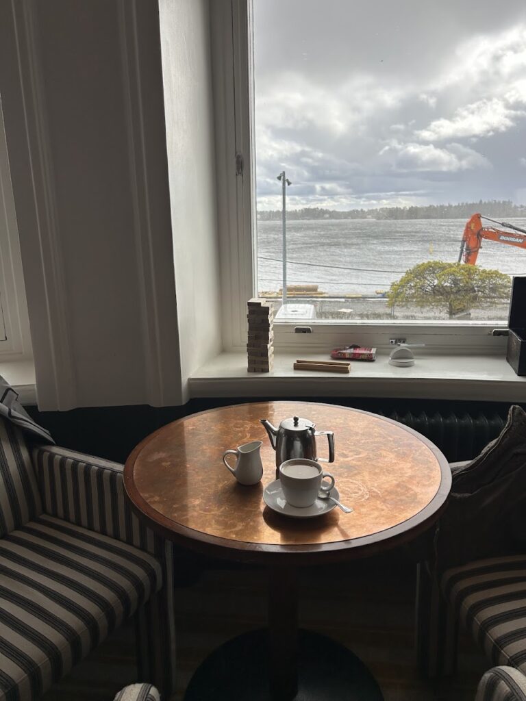 Cozy lounge inside Waxholms Hotell with striped armchairs and harbor views