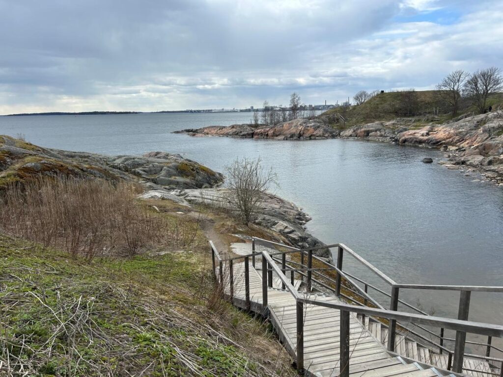 Coastal fortress setting at Suomenlinna with winding trails, historic walls, and green meadows