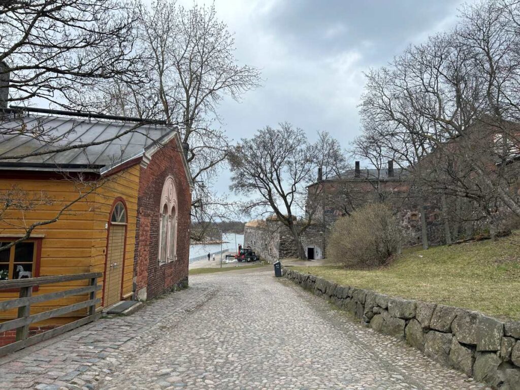 Scenic residential street on Suomenlinna lined with colorful wooden houses and lush greenery