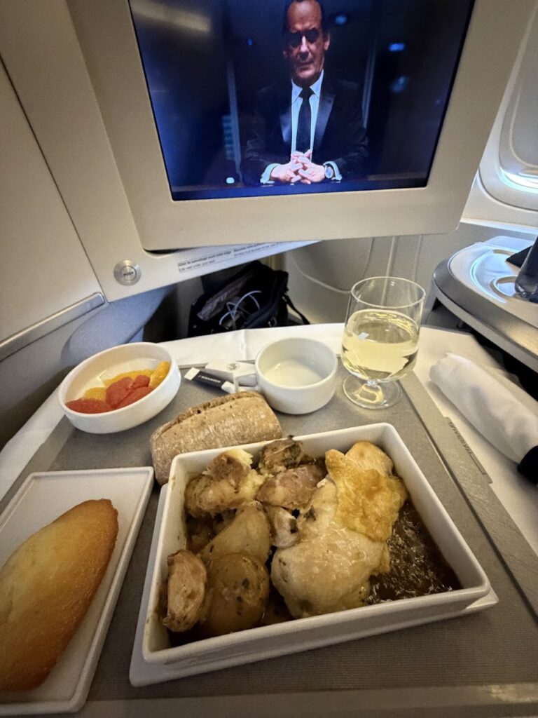 A traveler enjoying a roast chicken with tarragon jus and rissolé potatoes dinner onboard the Air France business class.