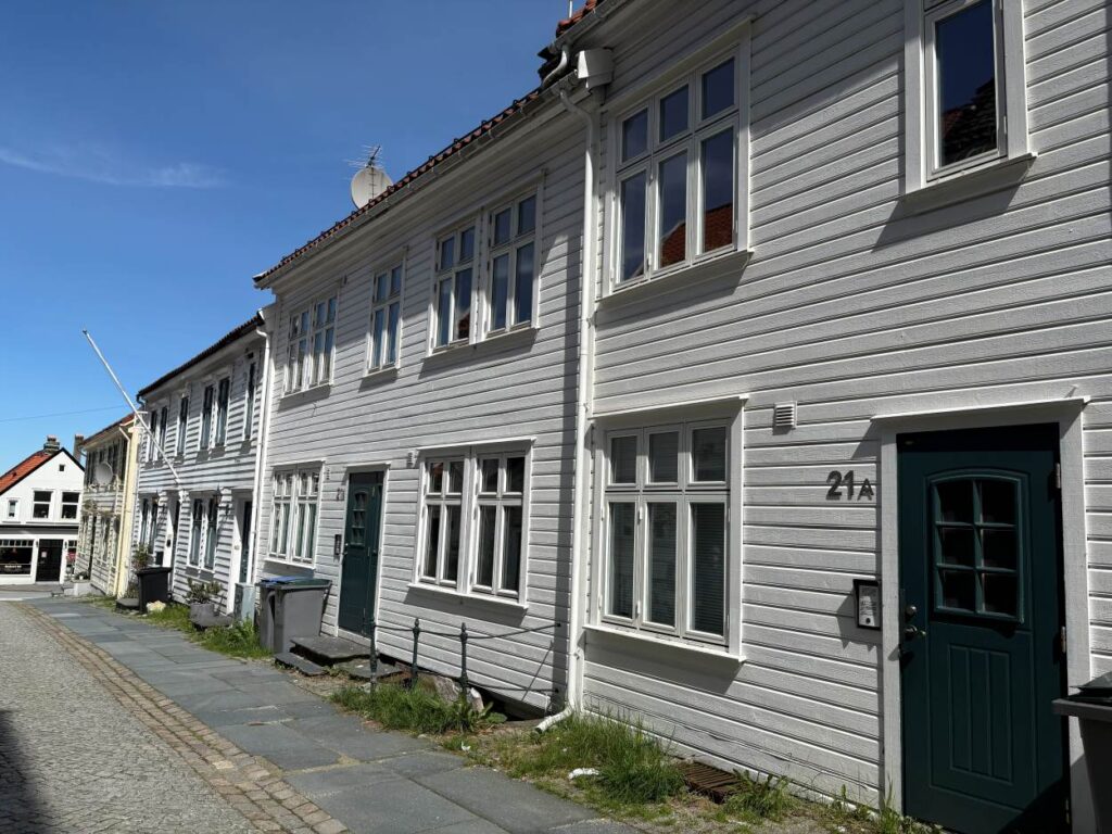 A calm street in Bergen lined by wooden houses and buildings.