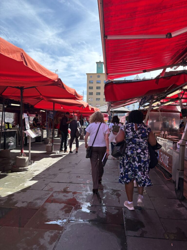 Visitors exploring the bustling Bergen Fish Market on a sunny day