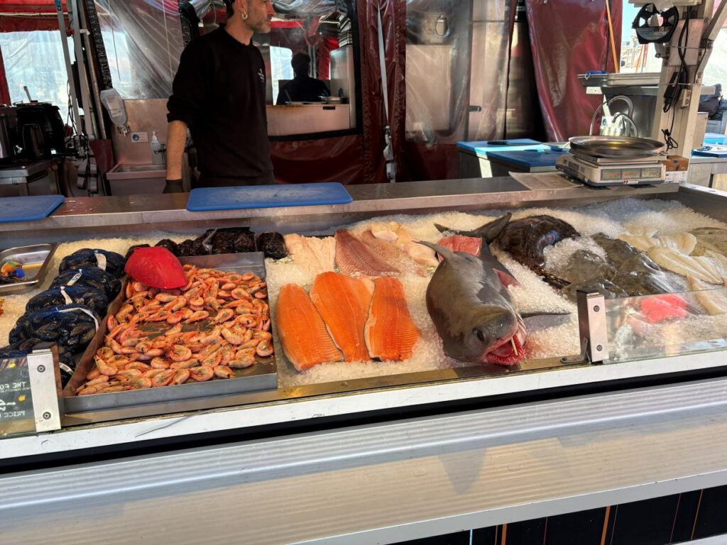 Open-air seafood market in Bergen Fish Market surrounded by colorful waterfront buildings