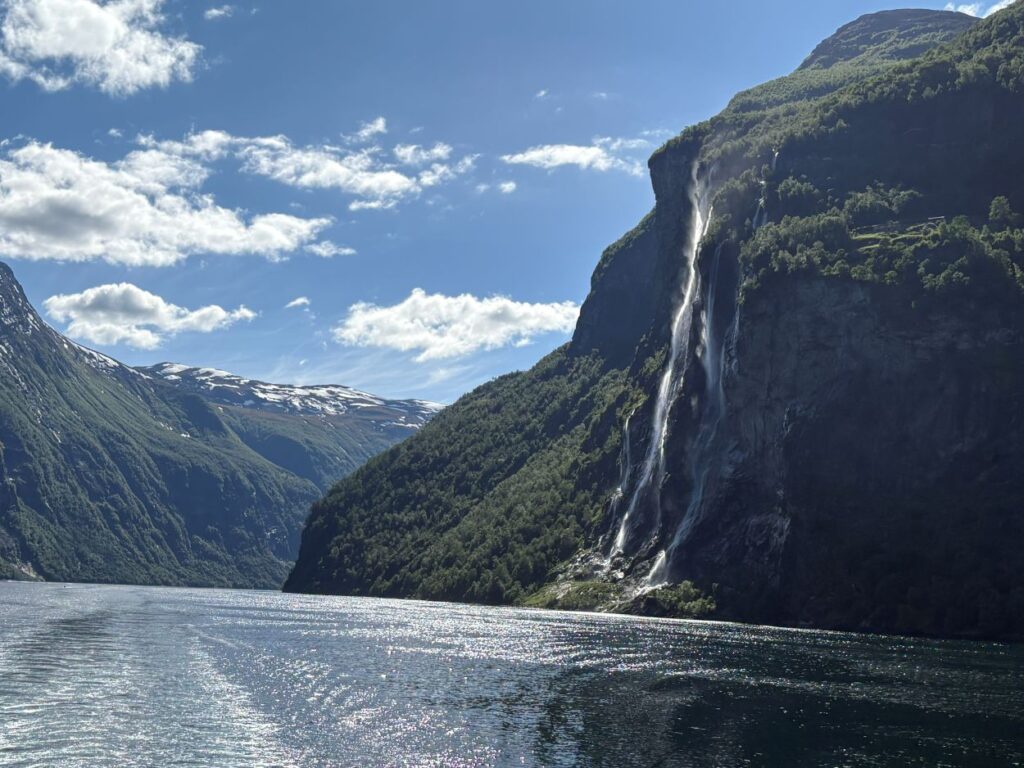 Waterfalls cascading into the deep blue waters of Geirangerfjord