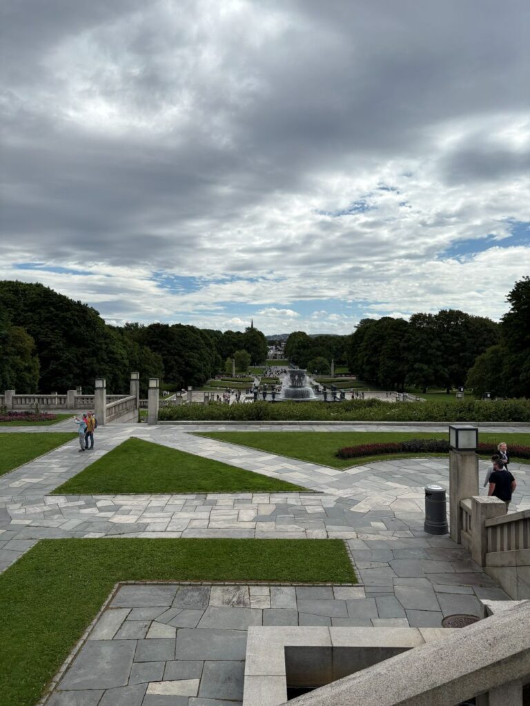 Visitors walking among Gustav Vigeland's iconic sculptures in Oslo's Frogner Park.