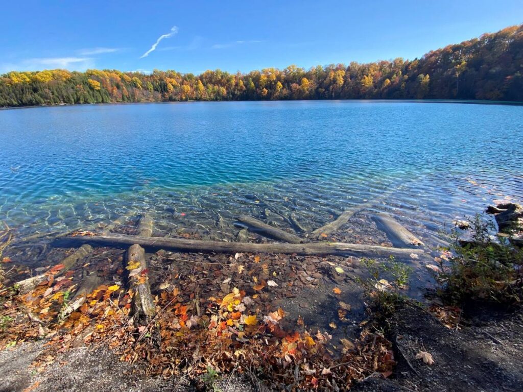 Autumn colors reflecting on Green Lakes State Park, one of the best things to do in Syracuse during fall.