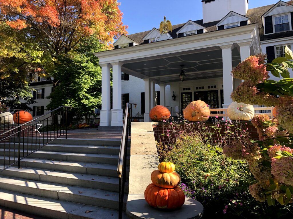 Spooky Halloween decorations outside classic Woodstock homes surrounded by fall foliage in Vermont in Fall