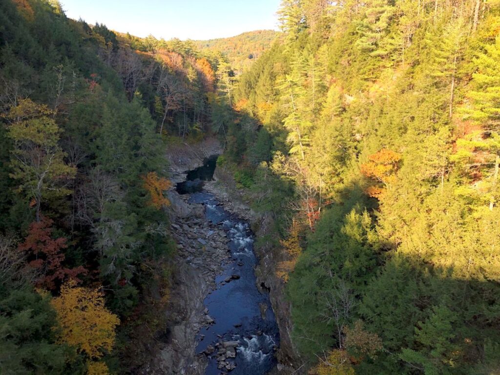 Colorful forests and rocky cliffs surrounding Quechee Gorge during Vermont in Fall