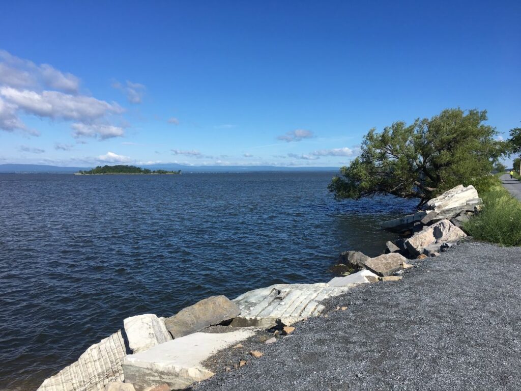 Colchester Causeway Trail extending into Lake Champlain beneath a crisp autumn sky during Vermont in Fall