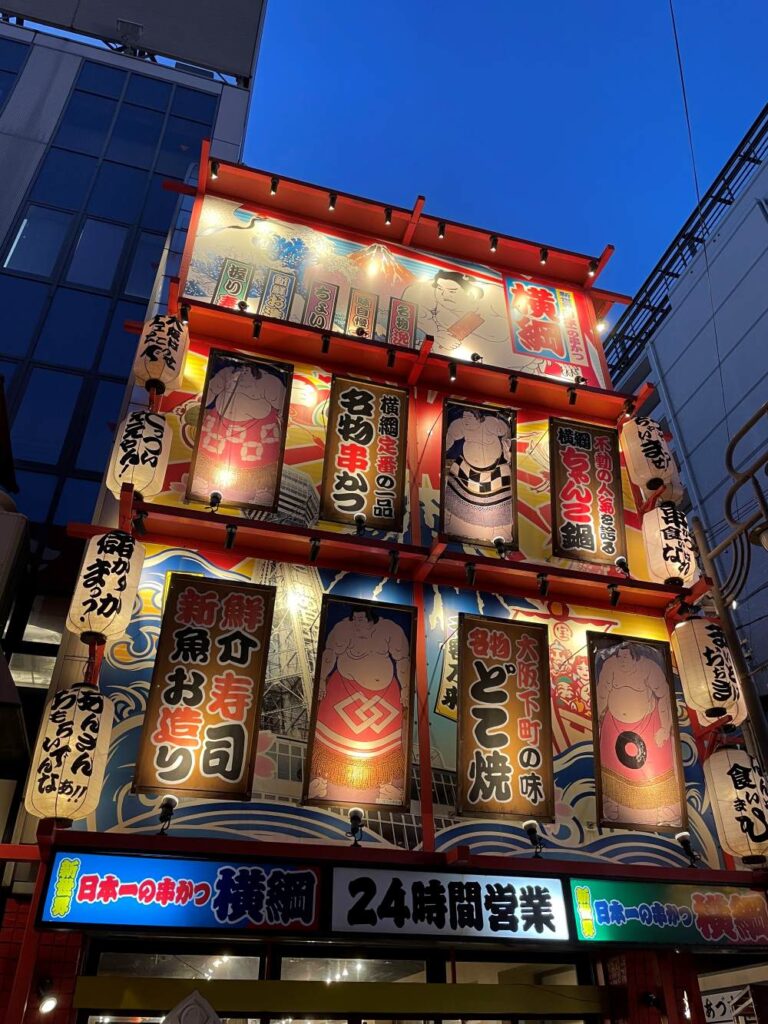 A neon light lit shopefront at Kuromon Ichiba Market, Osaka