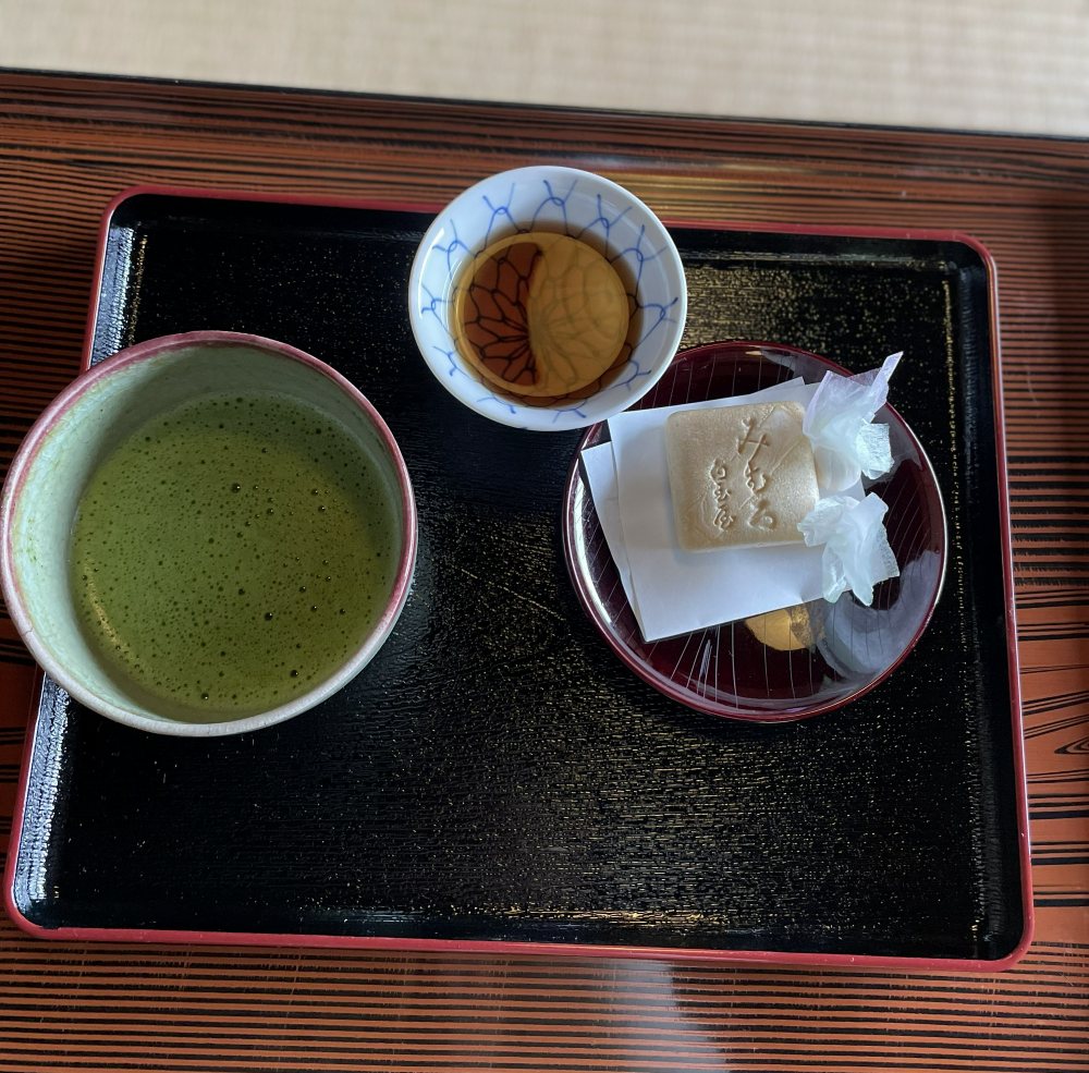 Tourists enjoying matcha tea at Isuien Garden after exploring Nara on a day trip from Osaka.
