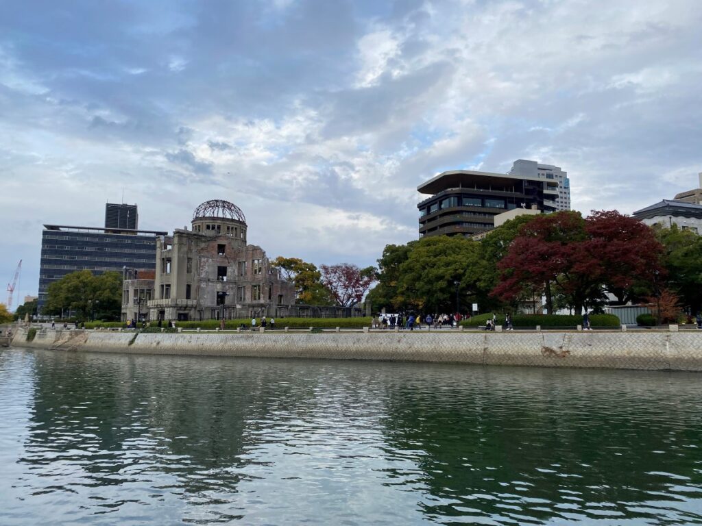 Hiroshima Peace Memorial Park in Japan with the Atomic Bomb Dome visible across the river on a peaceful autumn day